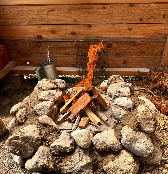石組みのファイアピットで燃える昼間の焚き火